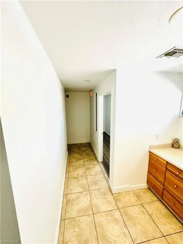 Hallway with light tile patterned flooring