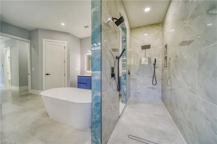Master Bathroom with vanity, a freestanding tub, recessed lighting, and a walk in shower
