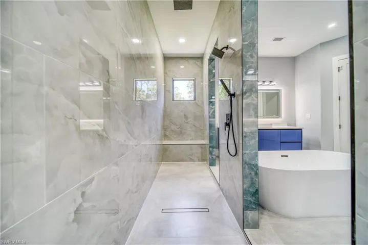 Master Bathroom with visible vents, a soaking tub, walk in shower, and vanity
