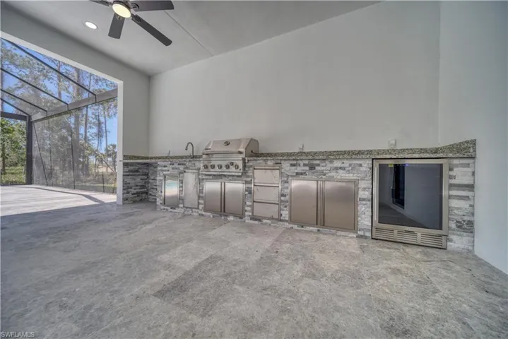 View of patio / terrace with a lanai, area for grilling, an outdoor kitchen, and ceiling fan