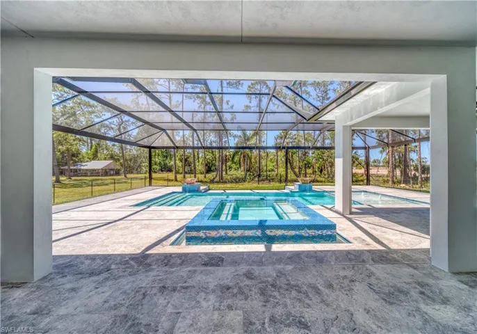 Outdoor pool featuring infinity spa, a lanai and a patio area