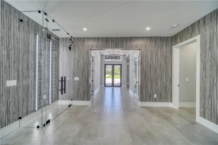 Entrance foyer featuring a notable chandelier, recessed lighting, french doors and wine closet