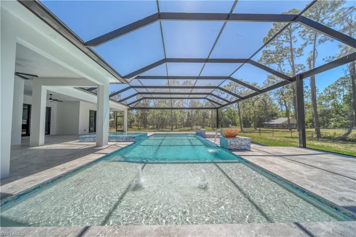 View of swimming pool featuring a patio area and screen enclosure
