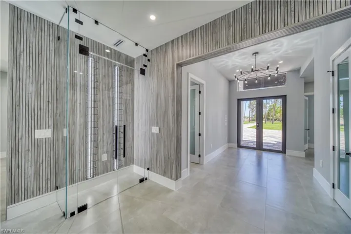 Custom Wine closet, LED lighting, french doors, and a chandelier
