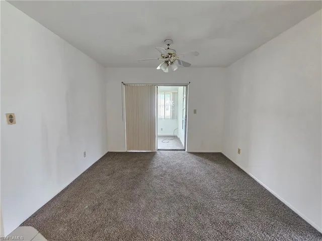 Wall-to-wall carpeting and a ceiling fan with integrated lighting
