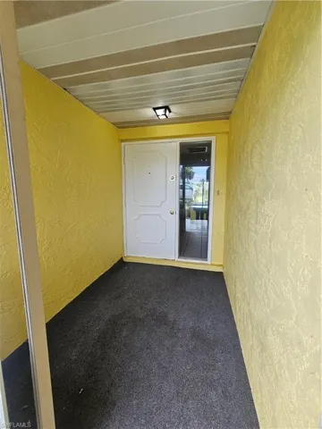 Covered entryway featuring textured yellow walls