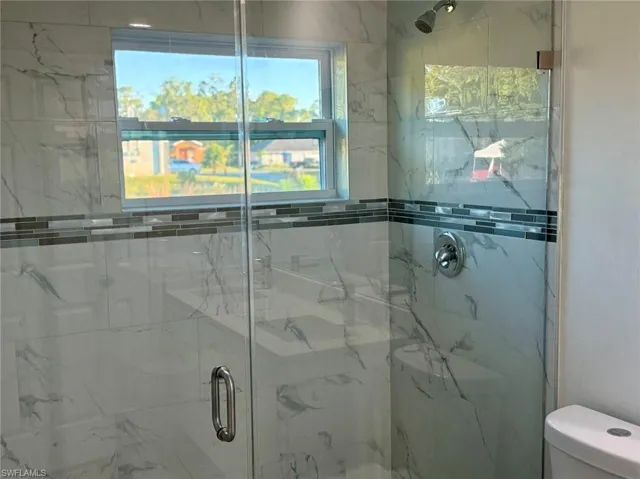 Bathroom with toilet and a shower with door