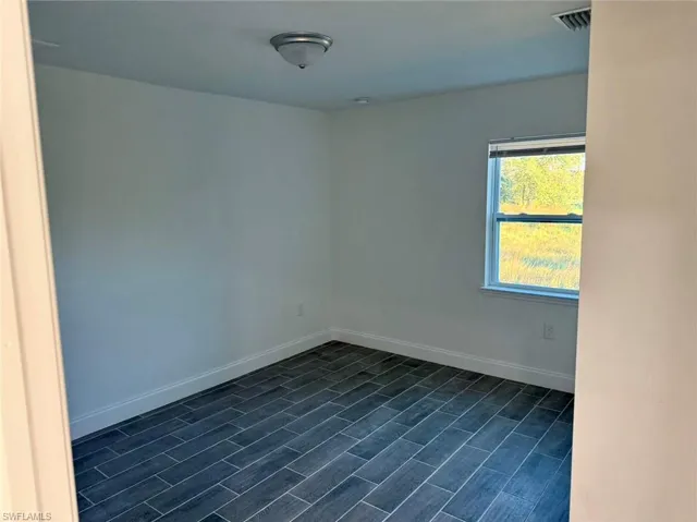 Unfurnished room featuring dark hardwood / wood-style floors