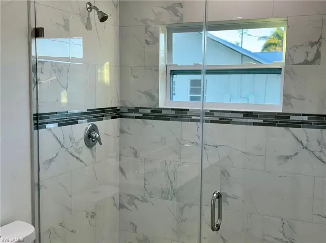 Bathroom with a shower with shower door and toilet
