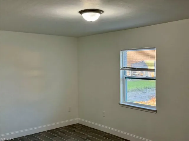 Unfurnished room featuring dark wood-type flooring