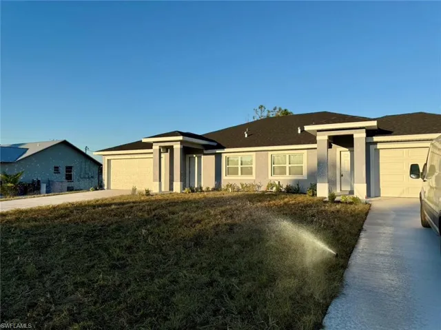 View of front of property featuring a front yard and a garage