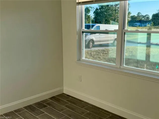 Empty room featuring dark hardwood / wood-style flooring