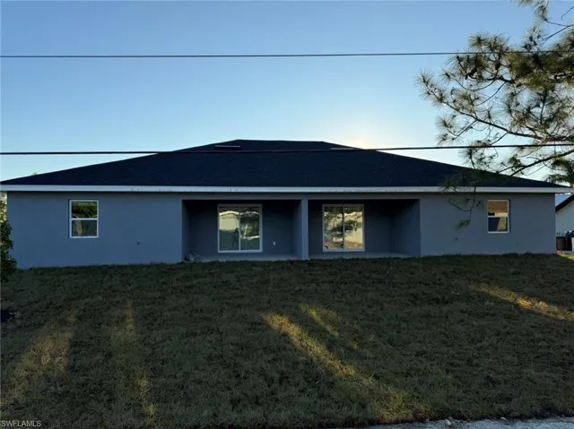 Back of house with a yard