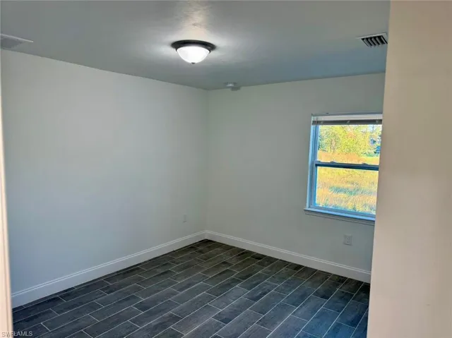 Unfurnished room featuring dark wood-type flooring