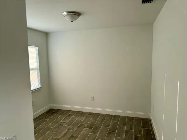 Unfurnished room with dark hardwood / wood-style flooring