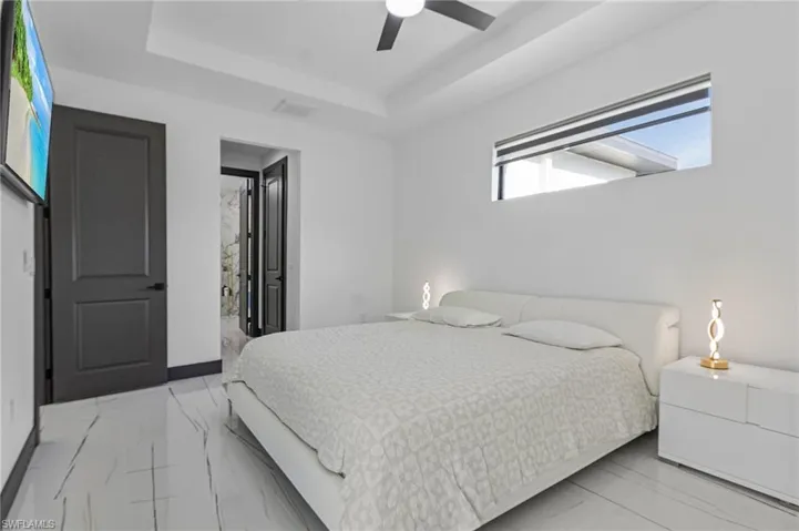 Bedroom featuring a tray ceiling and ceiling fan