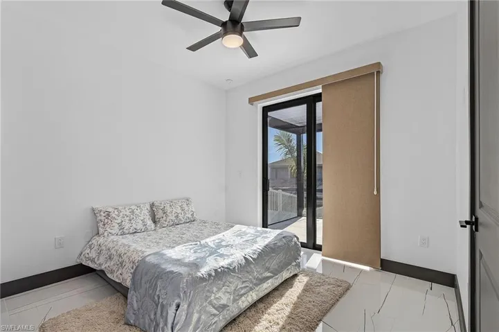 Tiled bedroom featuring access to exterior and ceiling fan