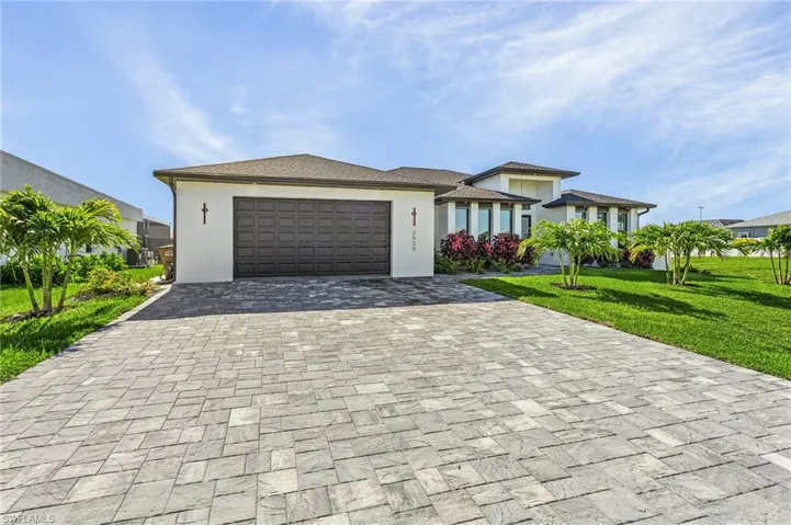 View of front of house featuring cooling unit, a garage, and a front lawn
