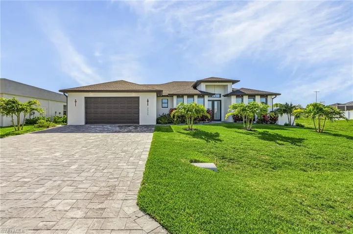 View of front facade with a garage and a front lawn