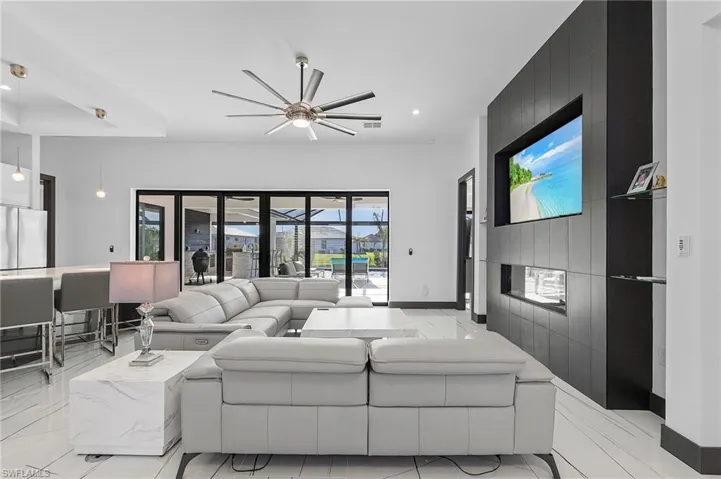 Living room featuring ceiling fan and tile walls