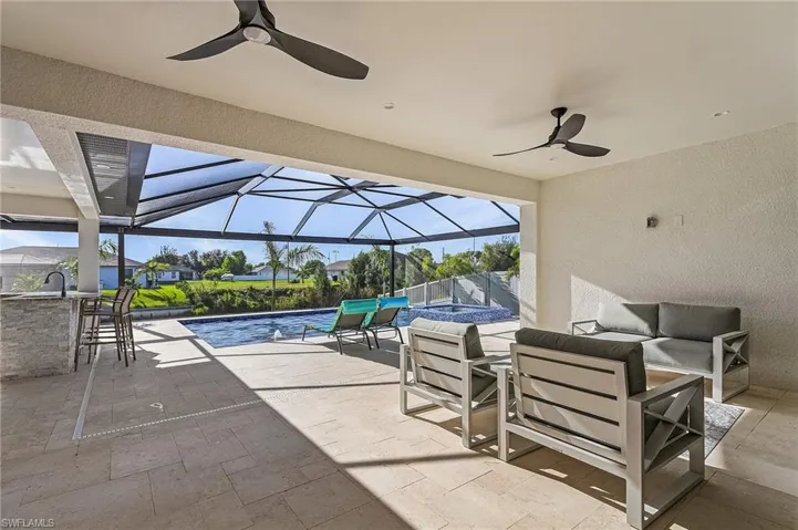 View of patio with outdoor lounge area, ceiling fan, and a lanai