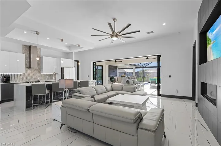 Tiled living room with a tray ceiling and ceiling fan