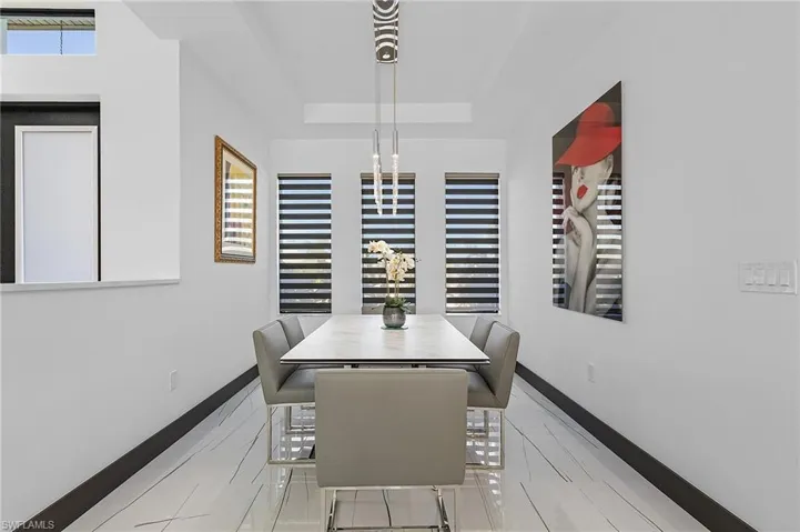 Dining area with a tray ceiling and light tile patterned floors