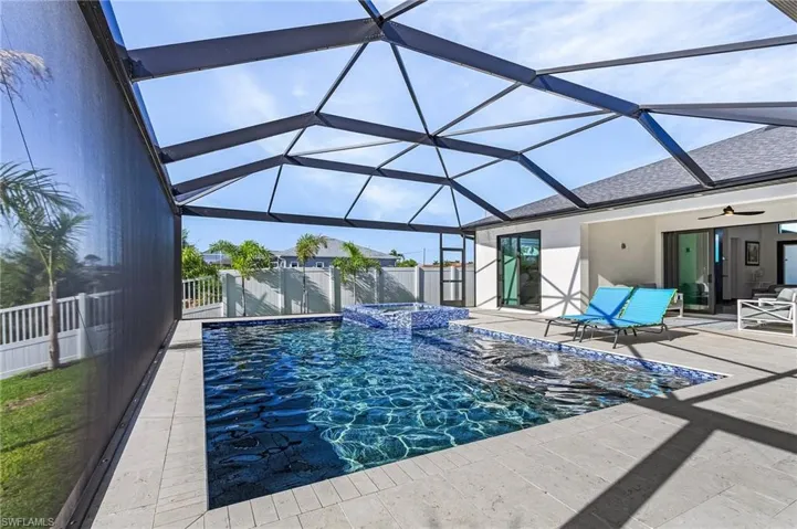 View of swimming pool featuring a lanai, a patio area, and ceiling fan