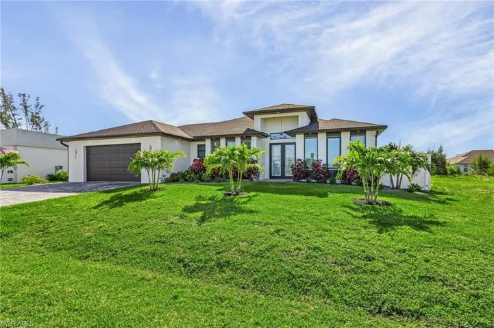View of front of home featuring a garage and a front lawn