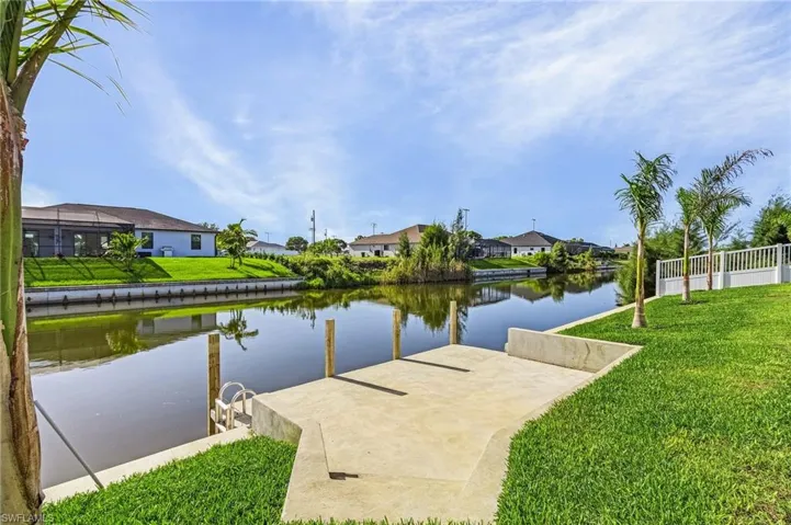 Dock area with a water view and a lawn