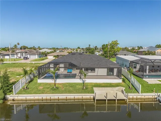 Back of property with a patio area, a yard, a fenced in pool, and a lanai