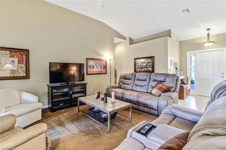 Carpeted living room with vaulted ceiling