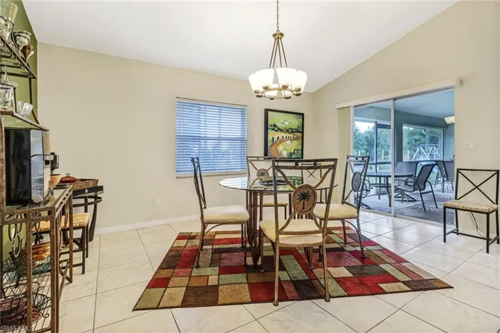 Dining space featuring vaulted ceiling, plenty of natural light, and light tile patterned floors