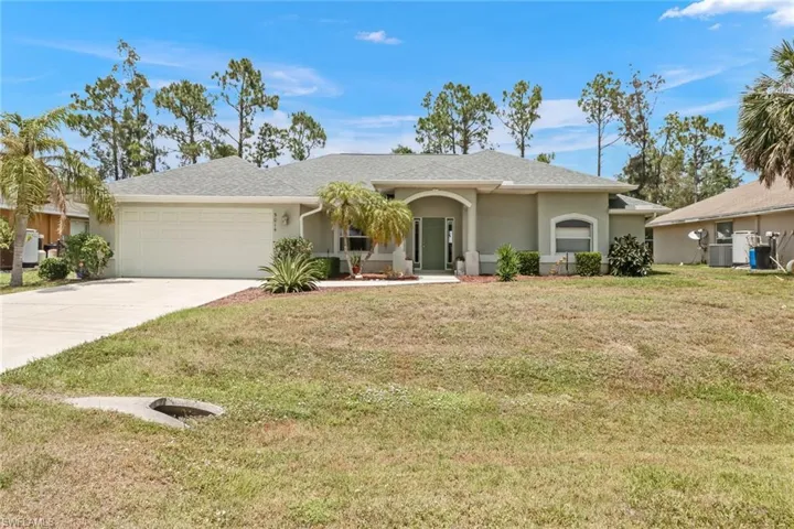 Ranch-style home with a garage, a front lawn, and central AC unit