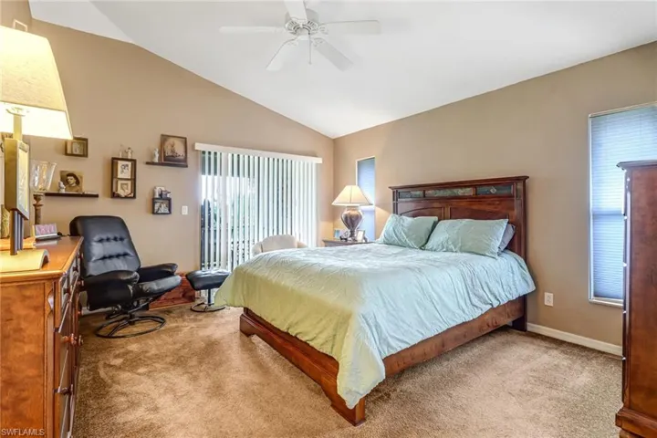Carpeted bedroom with lofted ceiling and ceiling fan