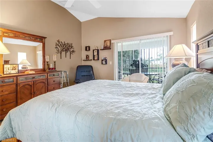 Bedroom featuring ceiling fan, vaulted ceiling, and access to exterior