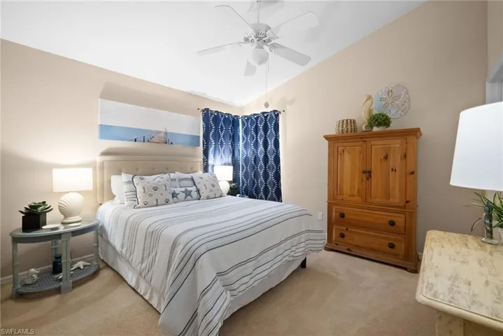 Bedroom with light carpet, lofted ceiling, and a ceiling fan