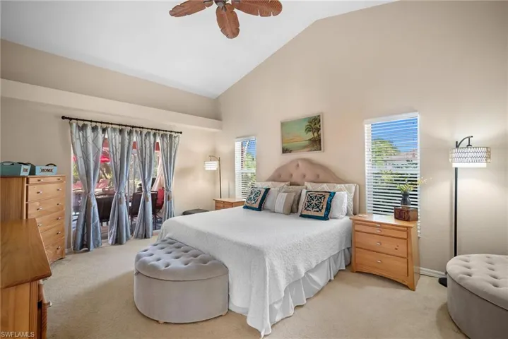Bedroom with access to outside, light carpet, a ceiling fan, and high vaulted ceiling