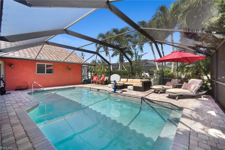Outdoor pool with a patio area, a sunroom, and glass enclosure