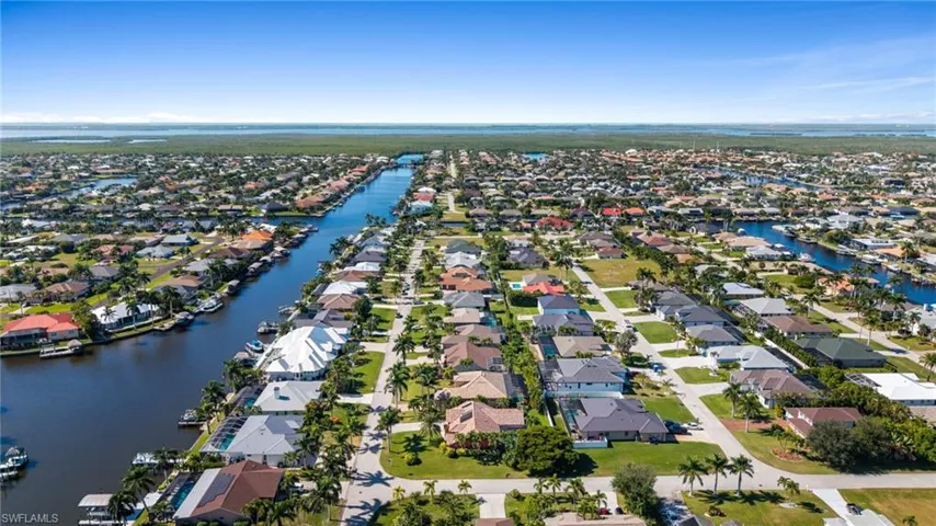 Aerial view of property's location featuring a nearby body of water and nearby suburban area
