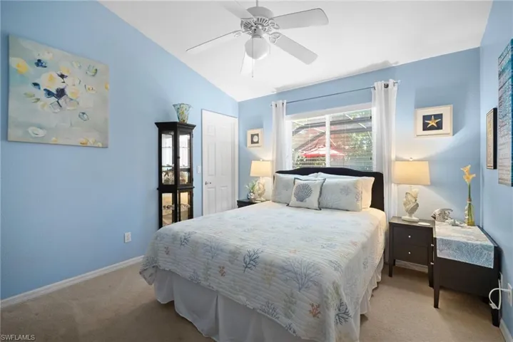 Carpeted bedroom with a ceiling fan and lofted ceiling