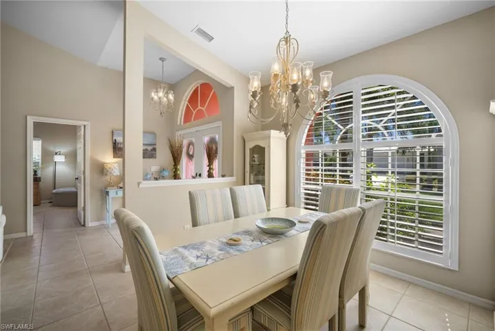 Dining area with light tile patterned flooring and a chandelier