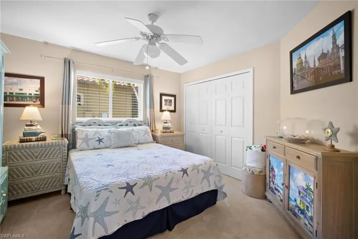 Carpeted bedroom with a closet and a ceiling fan