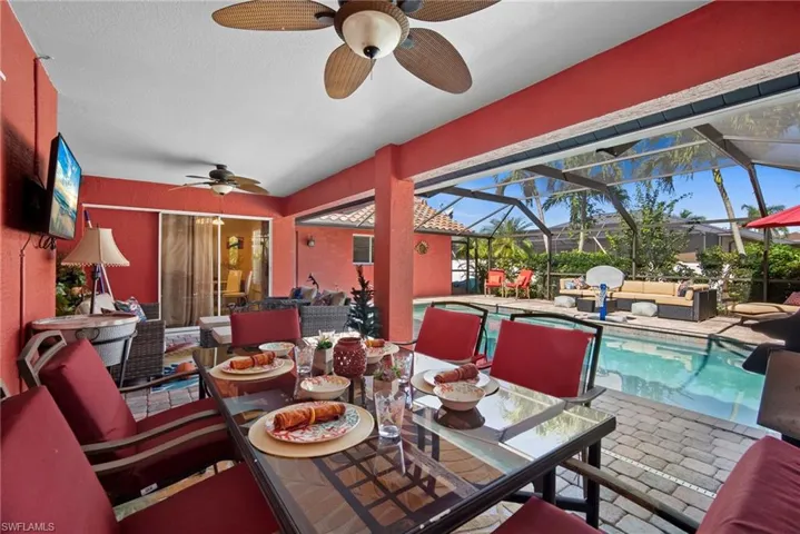 View of patio / terrace featuring an outdoor living space, a sunroom, an outdoor pool, ceiling fan, and outdoor dining space