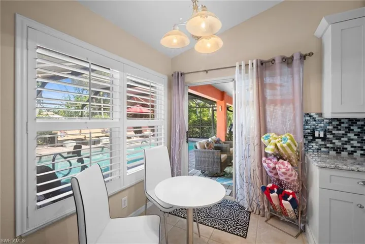 Dining room with light tile patterned floors and lofted ceiling
