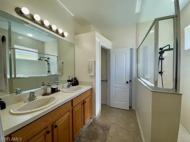 Bathroom featuring a double vanity with wood cabinetry and an integrated countertop