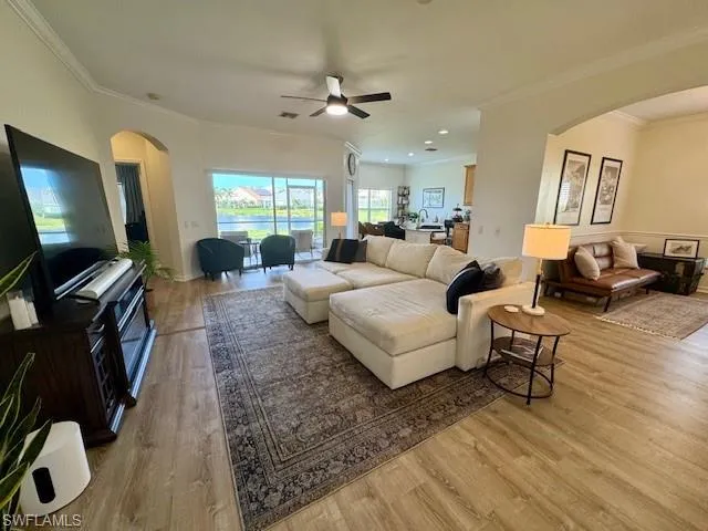 Spacious living area featuring wood-finish flooring and crown molding
