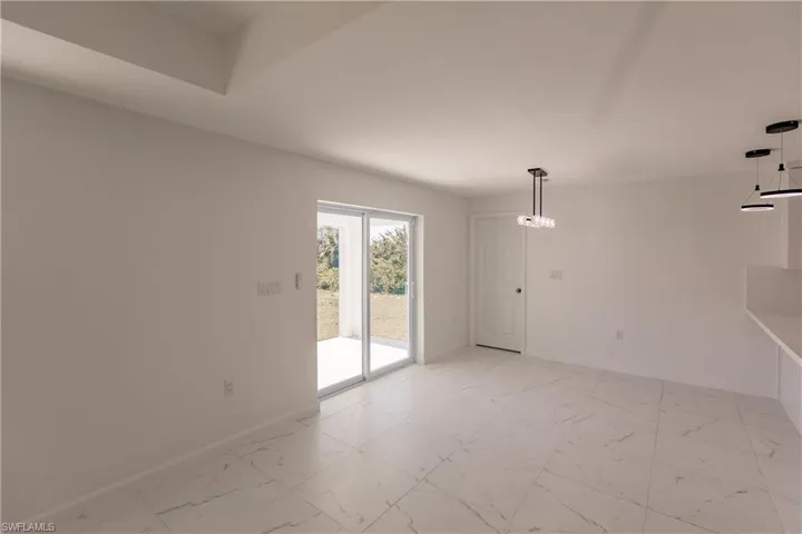 Unfurnished room featuring baseboards and light marble finish floors