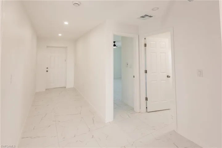 Corridor with recessed lighting and light marble finish flooring