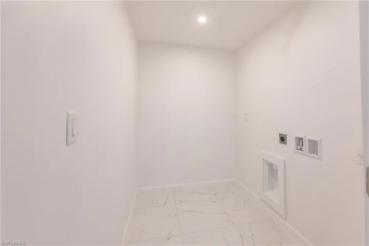 Laundry room with electric dryer hookup, marble look tiles, hookup for a washing machine, and recessed lighting